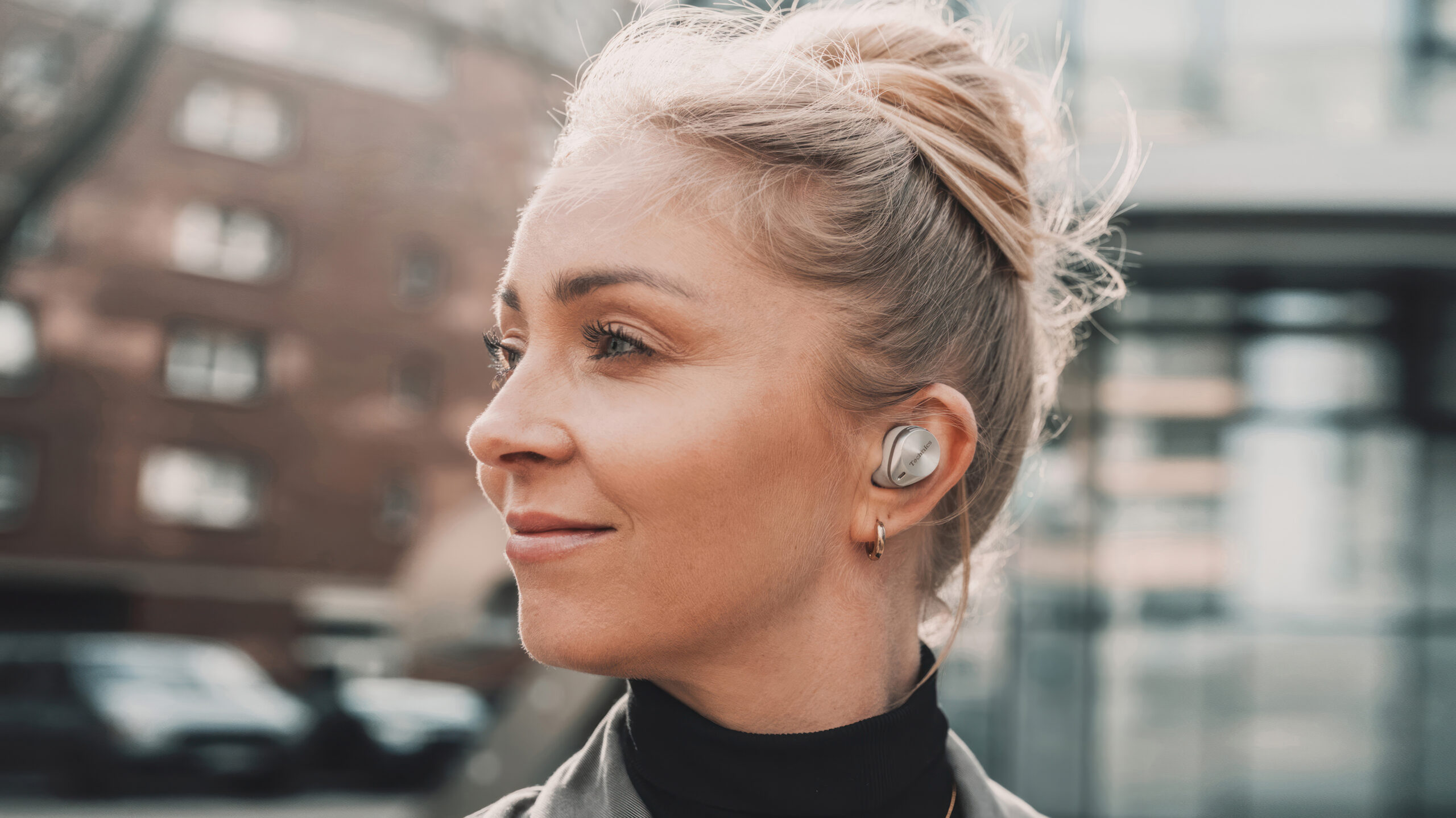 Buisness Woman outside with earbuds AZ80 by Technics