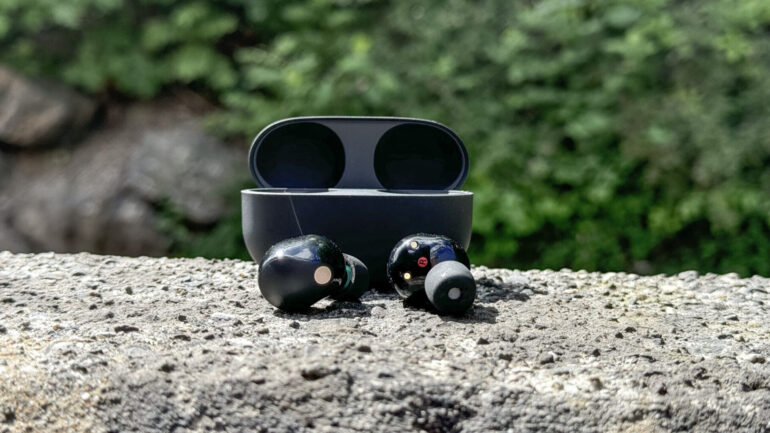 a pair of earbuds on a rock Sony WF-1000XM5 - spread